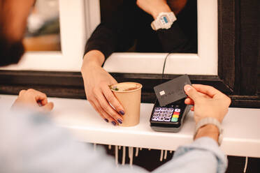 Kunde, der mit Kreditkarte bezahlt und Kaffee am Stand kauft - CAVF71649