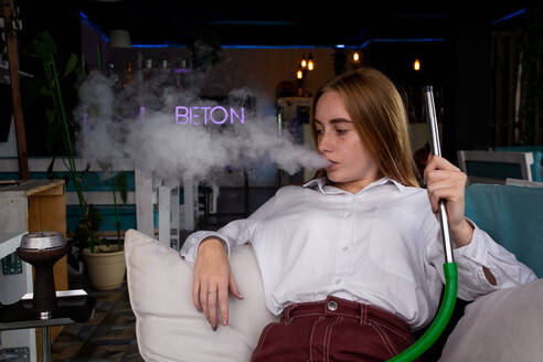 The girl lies on the couch and smokes hookah - CAVF71658