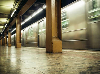 Innenansicht einer U-Bahn, die durch eine Station in NYC fährt - CAVF71694