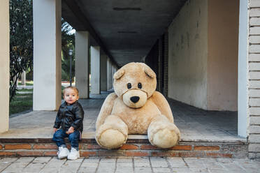 A little boy playing with a giant teddy bear. - CAVF71744