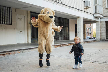 Ein kleiner Junge spielt mit einem riesigen Teddybären. - CAVF71745