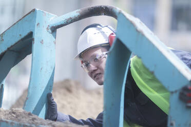 Bauingenieur beobachtet zwischen einem Container - CAVF71780