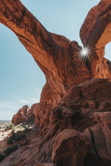 Sun flare shining through narrow rock crack between double-o-arch - CAVF71826