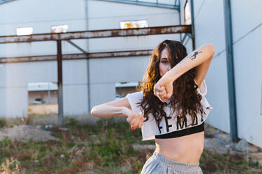 Powerful young dancer performing dance in abandoned building at sunset - CAVF71834