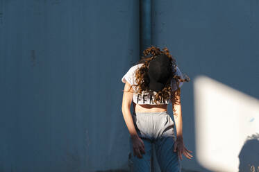 Excited dancer with long curly hair performing in abandoned building - CAVF71843