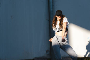 Excited dancer with long curly hair performing in abandoned building - CAVF71844