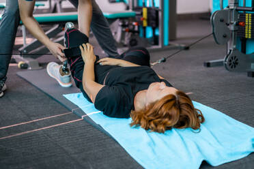 Personal trainer assisting woman with disabilities in her workout - CAVF72006