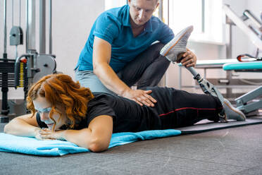 Personal trainer assisting woman with disabilities in her workout - CAVF72013