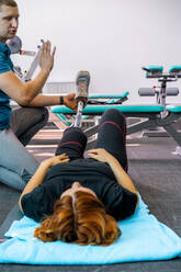 Personal trainer assisting woman with disabilities in her workout - CAVF72014