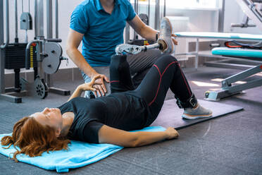 Personal trainer assisting woman with disabilities in her workout - CAVF72015