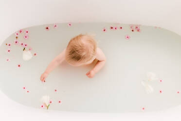 Baby in einem Blumenbad mit Kirschblüten - CAVF72059