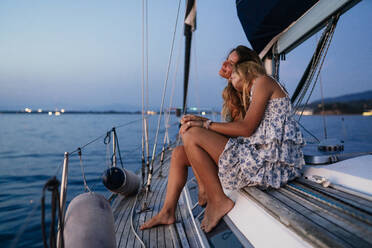 Close friends relaxing on sailboat in evening, Italy - CUF54180