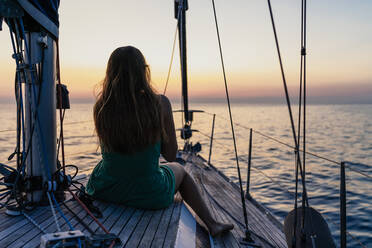Woman enjoying sunset on sailboat, Italy - CUF54183