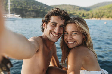 Couple taking selfie by seaside, Italy - CUF54202