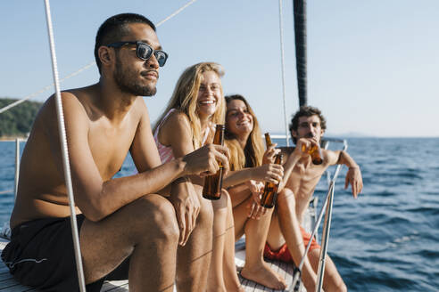 Freunde genießen Bier auf einem Segelboot, Italien - CUF54213