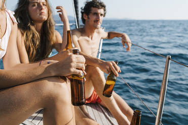 Freunde genießen Bier auf einem Segelboot, Italien - CUF54214
