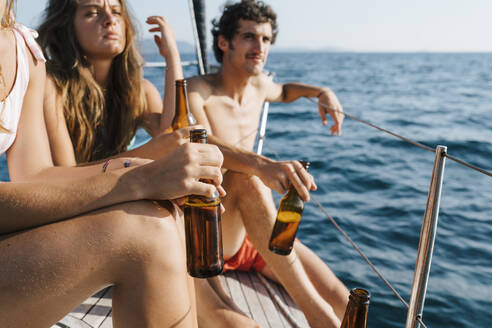 Friends enjoying beer on sailboat, Italy - CUF54214