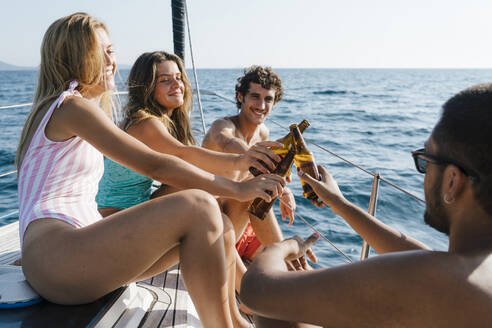 Freunde stoßen mit Bier auf einem Segelboot an, Italien - CUF54215