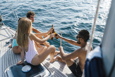 Friends toasting with beer on sailboat, Italy - CUF54216