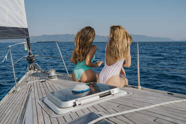 Freunde entspannen sich auf dem Deck eines Segelboots, Italien - CUF54247