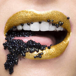 Goldene Lippen mit einem Mund voll schwarzem Kaviar - ISF23363