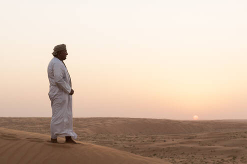 Omani Mann steht auf Sanddünen, Wahiba Sands Wüste, Oman - ISF23446