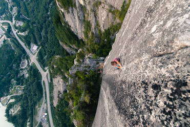 Rock climber with friends climbing Heatwave, on top of The Chief, Squamish, Canada - ISF23471