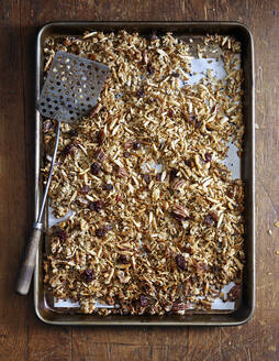 Overhead view of granola in tray on wooden table - CAVF72331