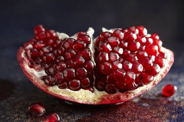 Close-up of pomegranate slice on table - CAVF72332