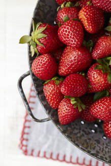 Draufsicht auf Erdbeeren im Sieb auf dem Tisch - CAVF72340