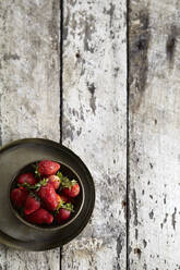 Draufsicht auf Erdbeeren in einer Schale auf einem Holztisch - CAVF72343