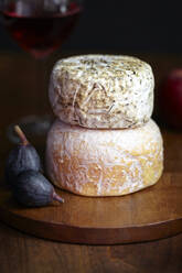 Close-up of cheese and figs on cutting board - CAVF72347