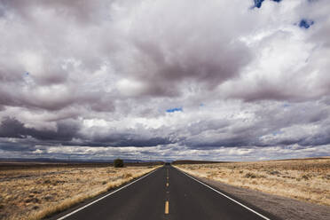 High angle view of country road against stormy clouds - CAVF72389