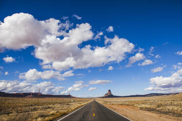 Landstraße inmitten von Feldern vor bewölktem Himmel im Monument Valley - CAVF72396