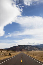 Country road against mountains and cloudy sky - CAVF72400