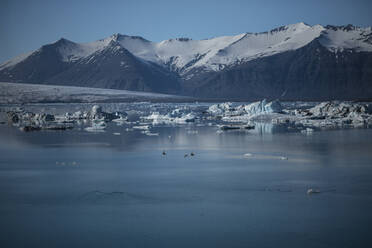 Scenic view of sea by snowcapped mountain against sky - CAVF72420