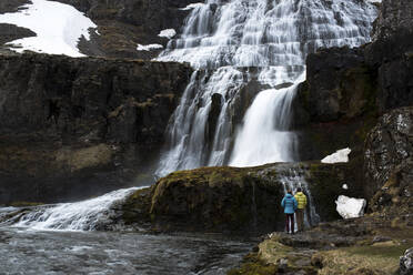 Rückansicht eines stehenden Paares mit Blick auf einen Wasserfall - CAVF72439