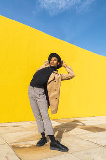 Junger Mann tanzt vor einer gelben Wand - AFVF04535