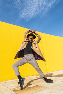 Junger Mann tanzt vor einer gelben Wand - AFVF04538