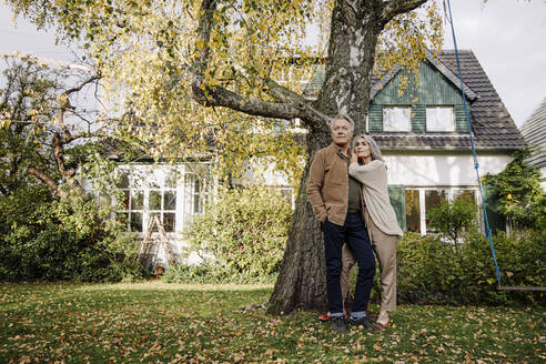 Älteres Ehepaar im Garten ihres Hauses im Herbst - GUSF02982