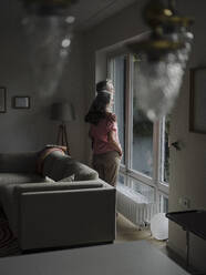 Senior couple looking out of window at home - GUSF03015
