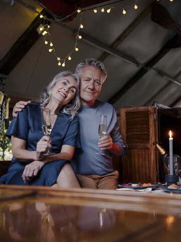 Porträt eines älteren Paares beim Candlelight-Dinner auf einem Boot im Bootshaus, lizenzfreies Stockfoto