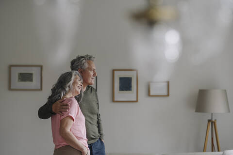 Älteres Ehepaar steht im Wohnzimmer zu Hause, lizenzfreies Stockfoto