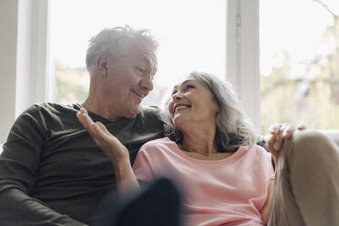 Happy senior couple relaxing on couch at home - GUSF03055