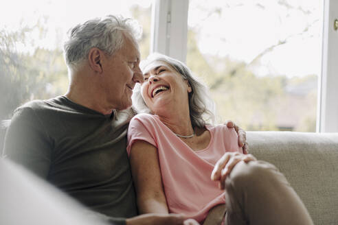 Happy senior couple relaxing on couch at home - GUSF03059