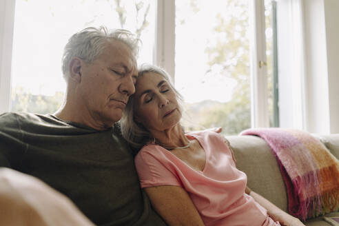 Senior couple napping on couch at home - GUSF03061