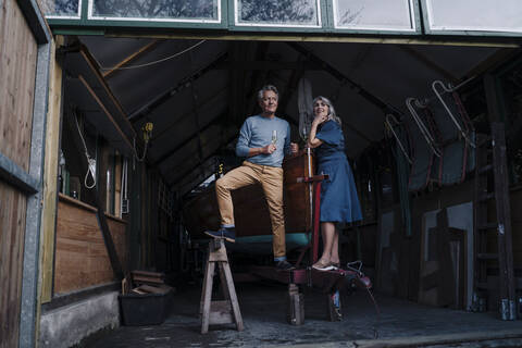 Senior couple in a boathouse with glass of champagne stock photo