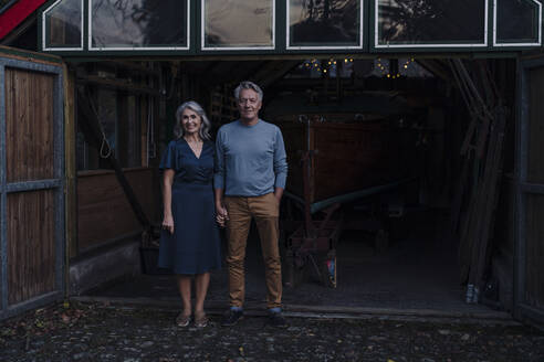 Senior couple standing in front of boathouse - GUSF03089