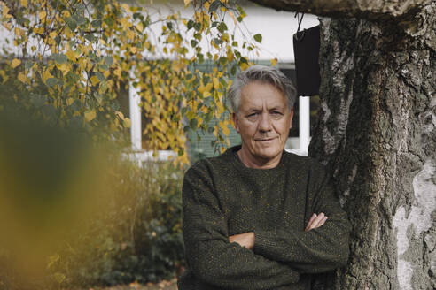 Porträt eines älteren Mannes an einem Baum im Garten - GUSF03104