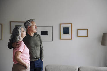 Senior couple standing in living room at home - GUSF03119